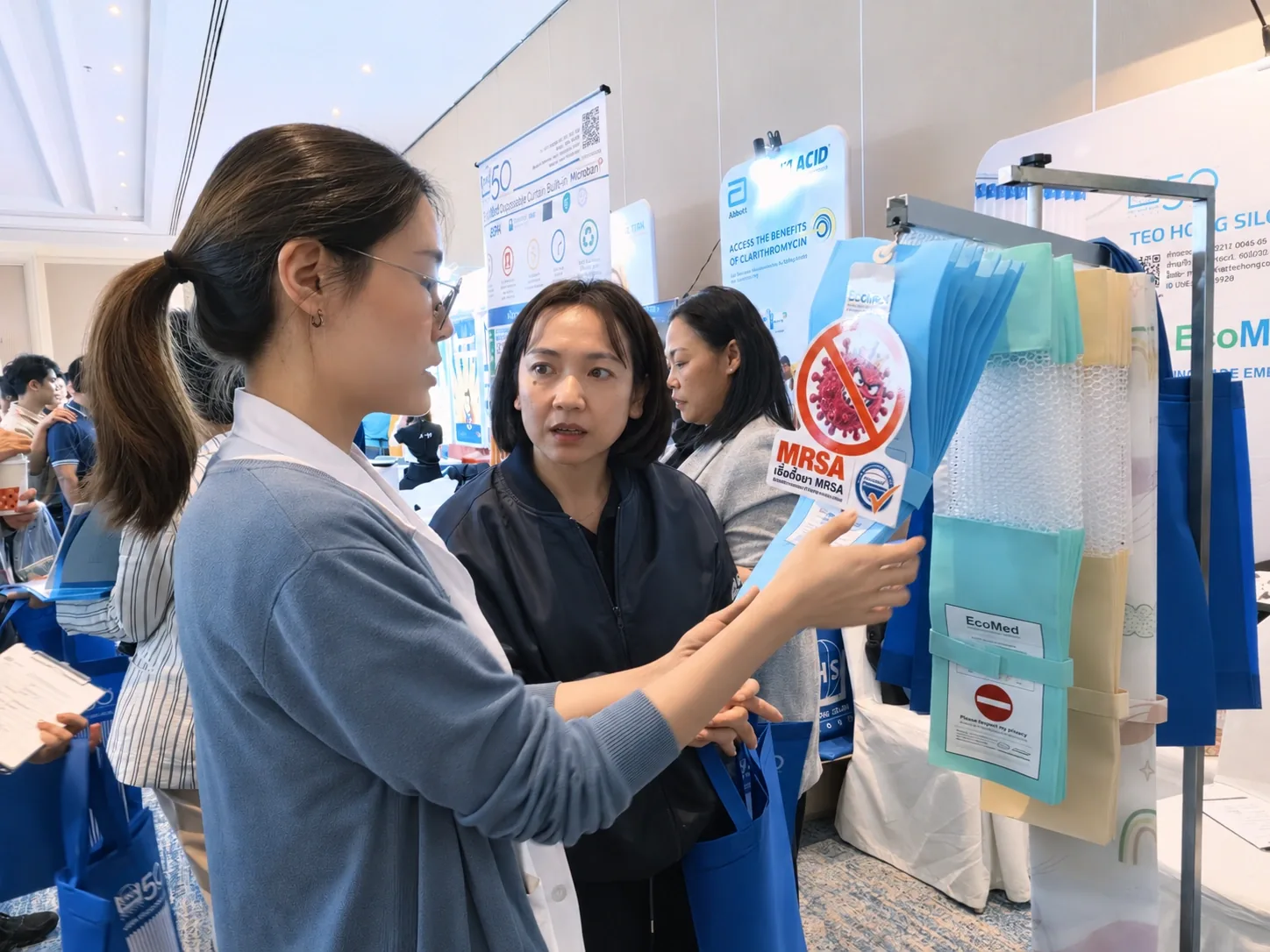 Team member explaining EcoMed curtains with the MRSA protection tag