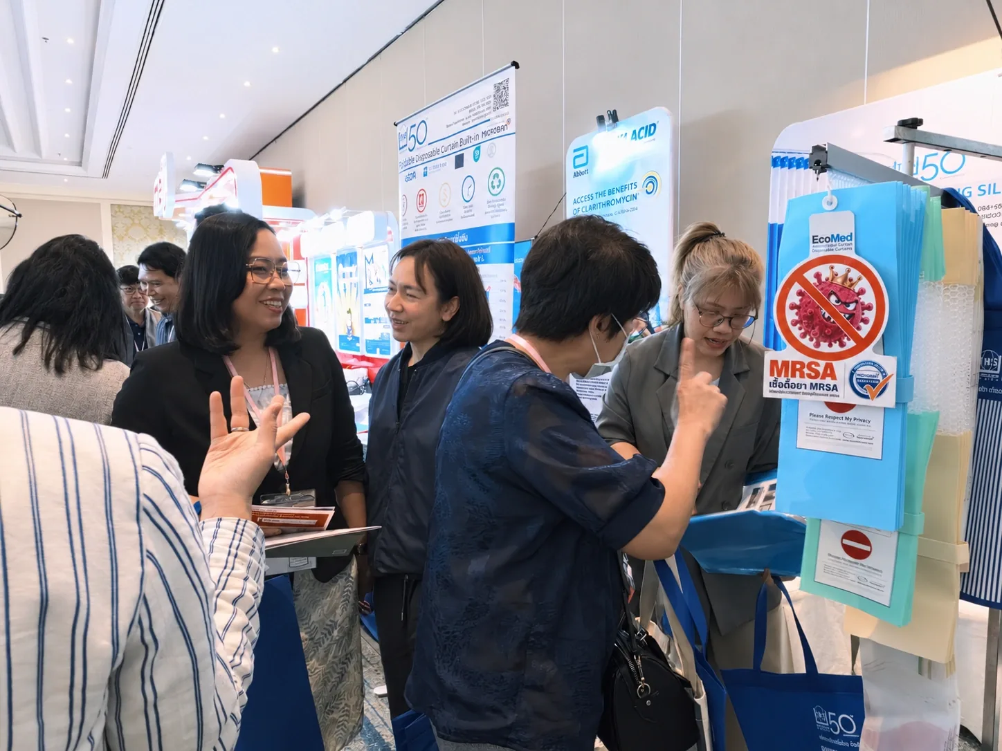 Visitors talking with the team near the booth