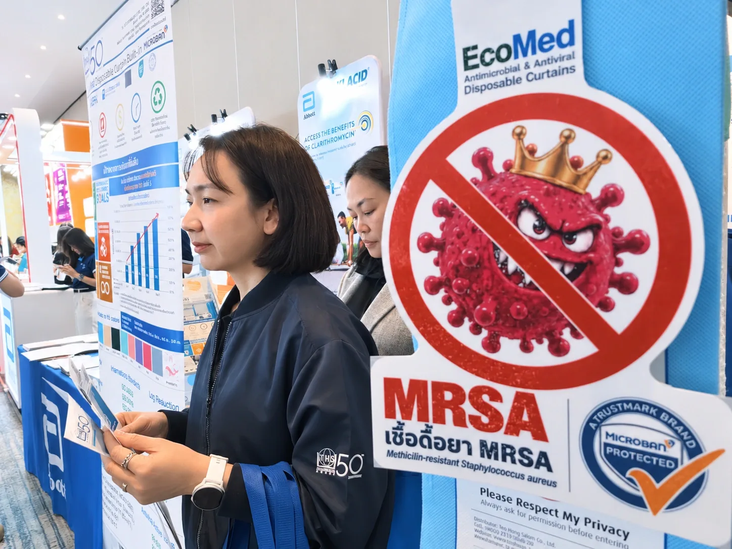 An attendee reading product information beside the EcoMed curtain samples