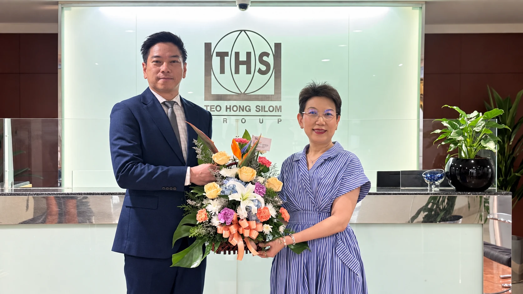 Ms. Kanyakorn Sirirat-Asdon receiving congratulatory flowers after ISO 9001 certification