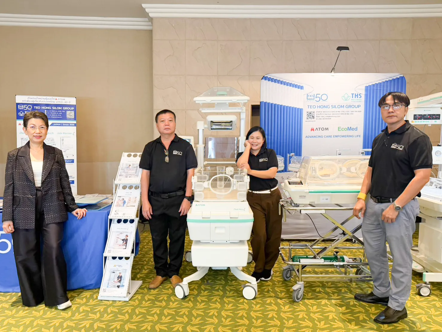 Team members at the booth with ATOM Medical equipment